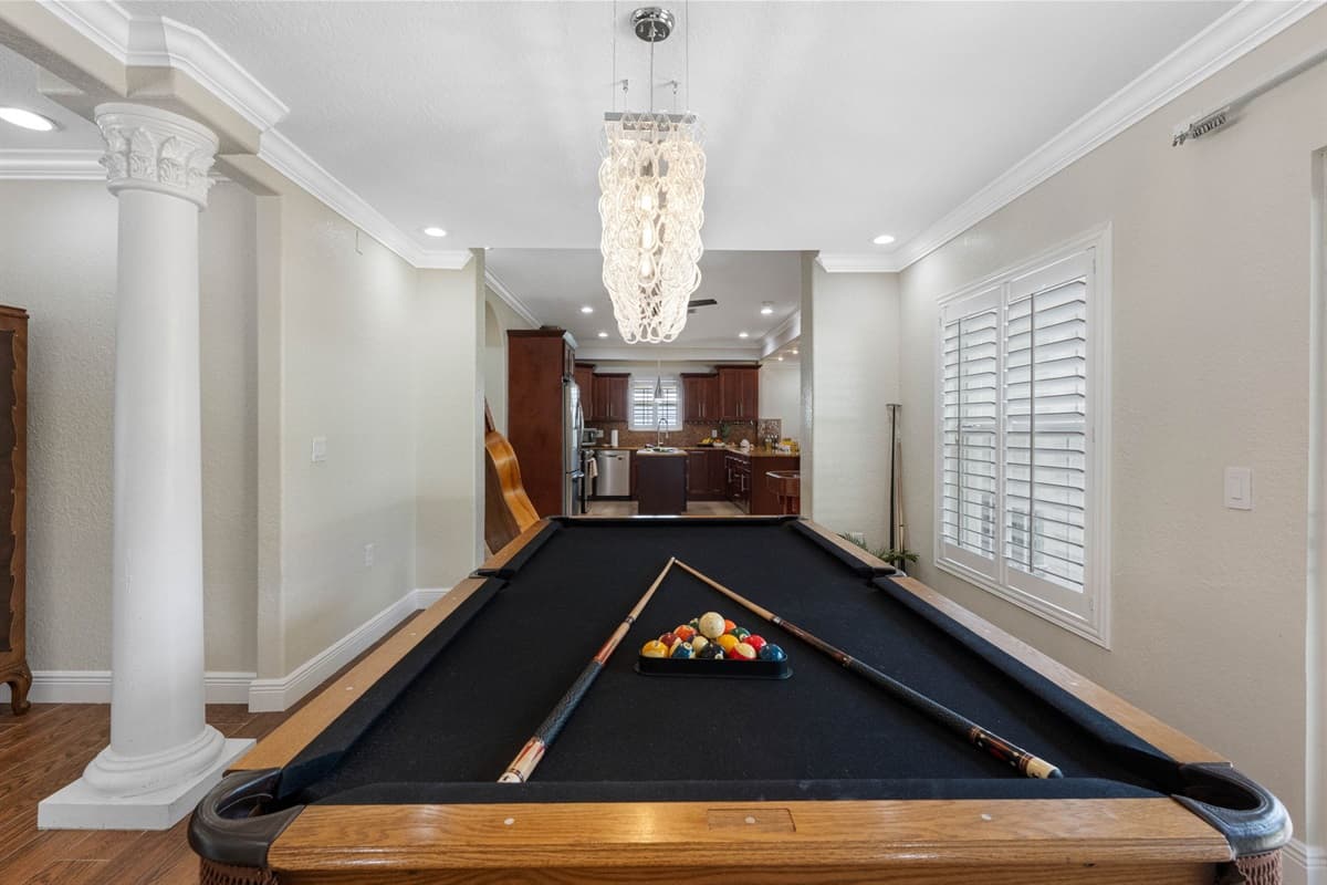 Enjoy a game of billiards while taking in the scenic waterfront backdrop. This game room boasts warm wood flooring, modern lighting, and easy access to the outdoor patio.