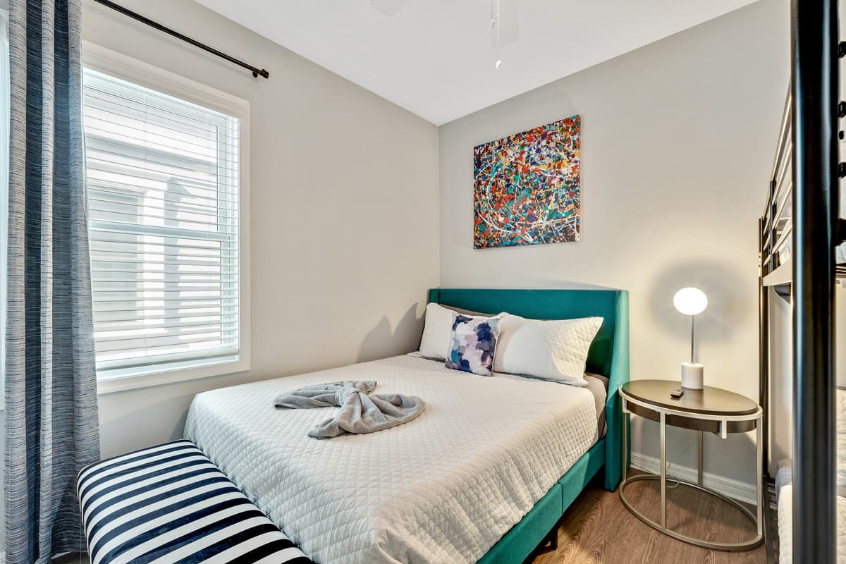The queen-size bed provides a comfortable retreat, while the bunk bed introduces an element of fun and functionality.