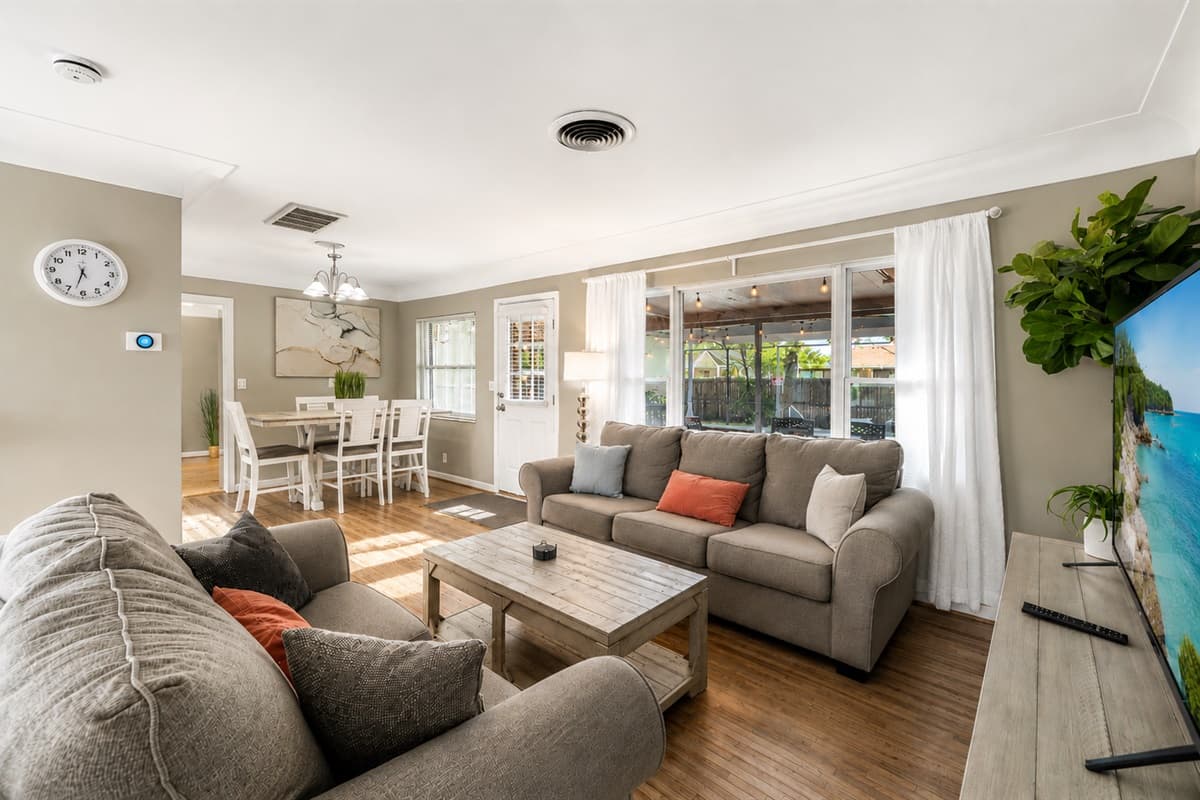 Spacious open-concept living area featuring comfortable sofas, large windows, and plenty of natural light.