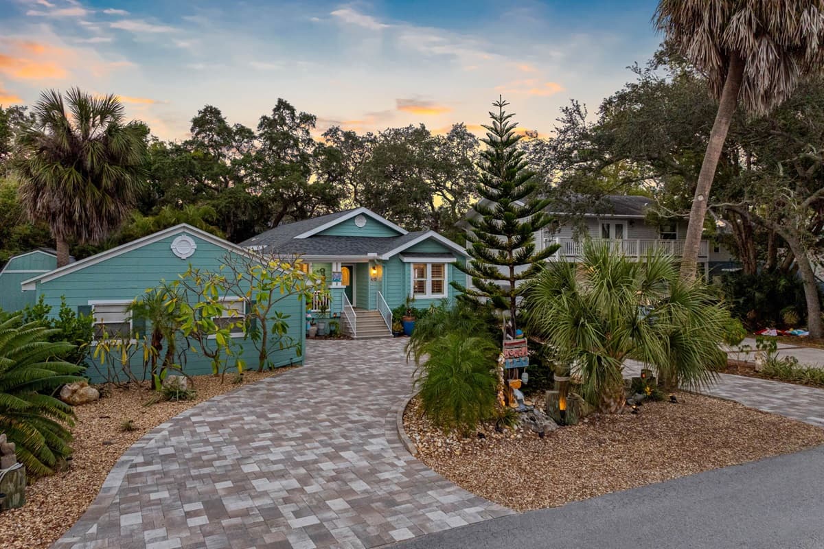 A well-kept front porch and tropical landscaping complement the home’s stylish modern-coastal finish.