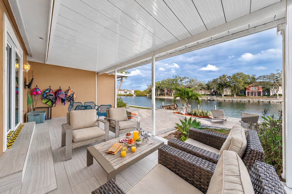 Relax on the covered waterfront patio with comfortable outdoor seating and beautiful lake views.