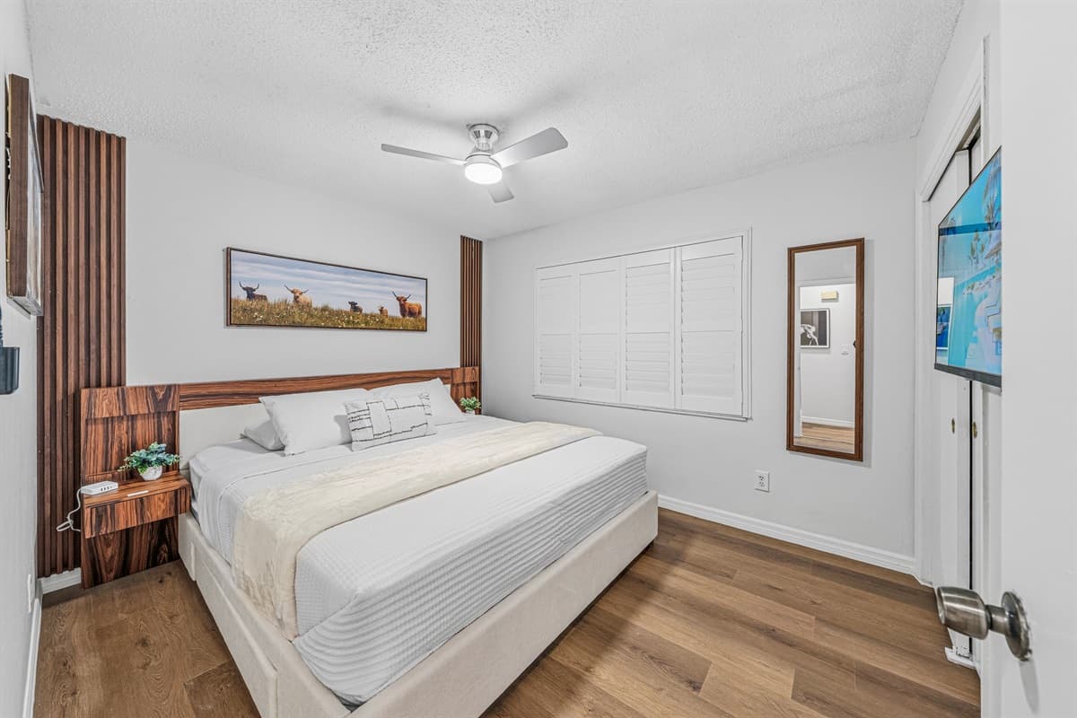 Comfortable king bedroom with warm wood accents, stylish décor, and a cozy, inviting feel 