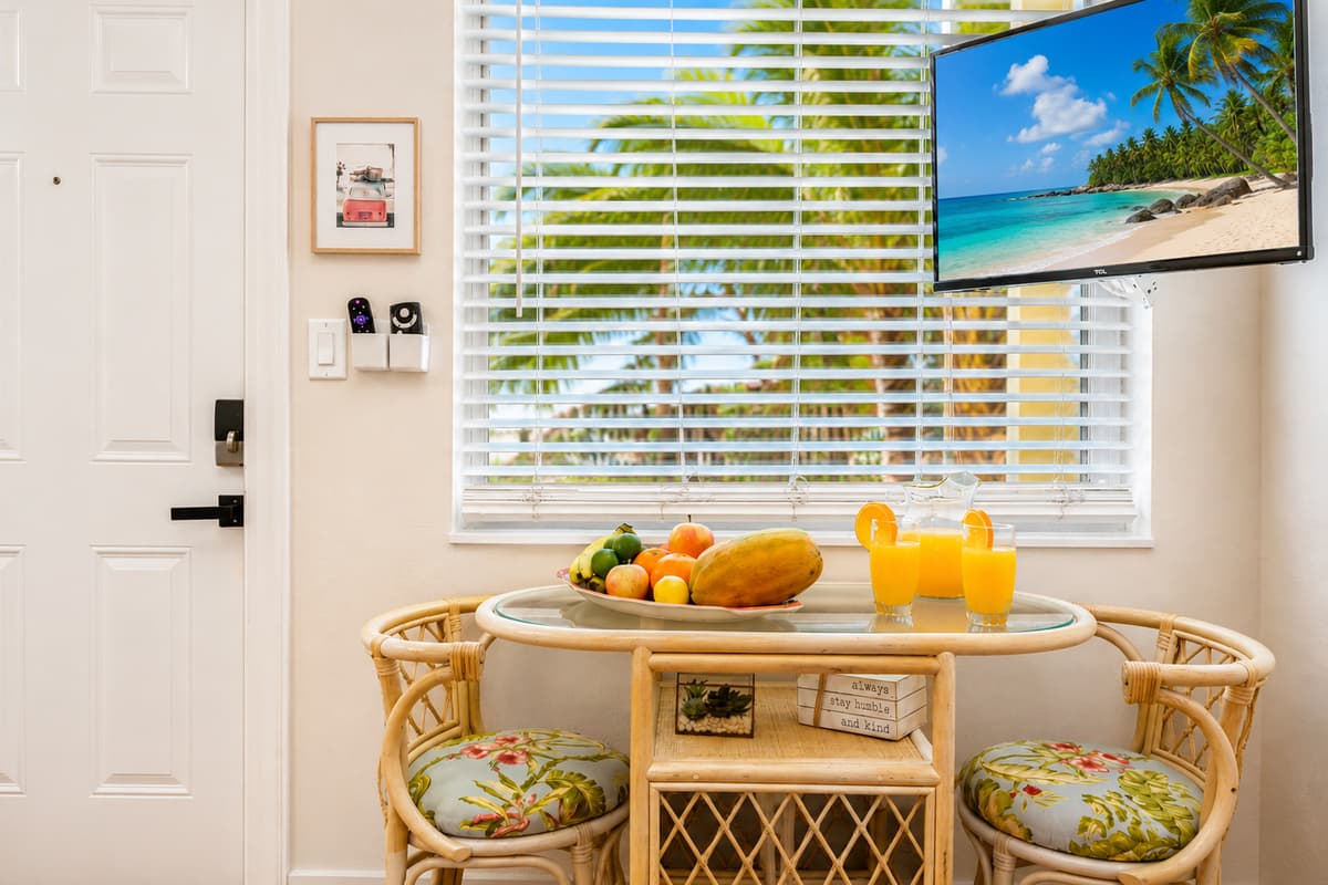 Enjoy breakfast or a cozy dinner at the charming dining table, perfectly positioned beside sunny windows with tropical views.