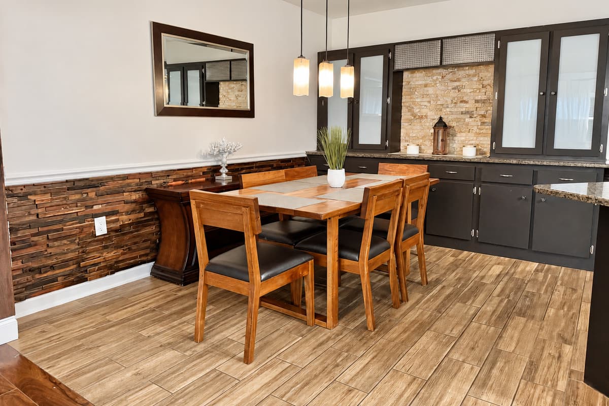 Enjoy cozy meals or family game nights around this modern wooden dining table, set under warm pendant lighting and open to both the kitchen and living room.
