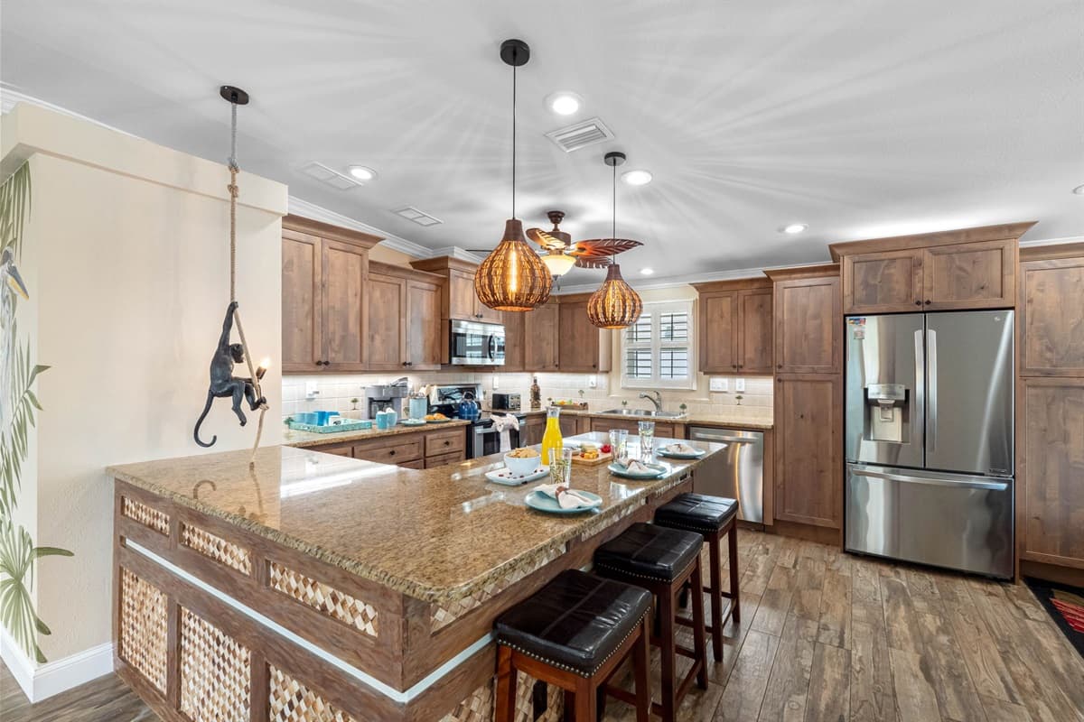 A bright and inviting kitchen, equipped with everything you need: coffee bar, cookware, breakfast bar seating, and premium appliances.