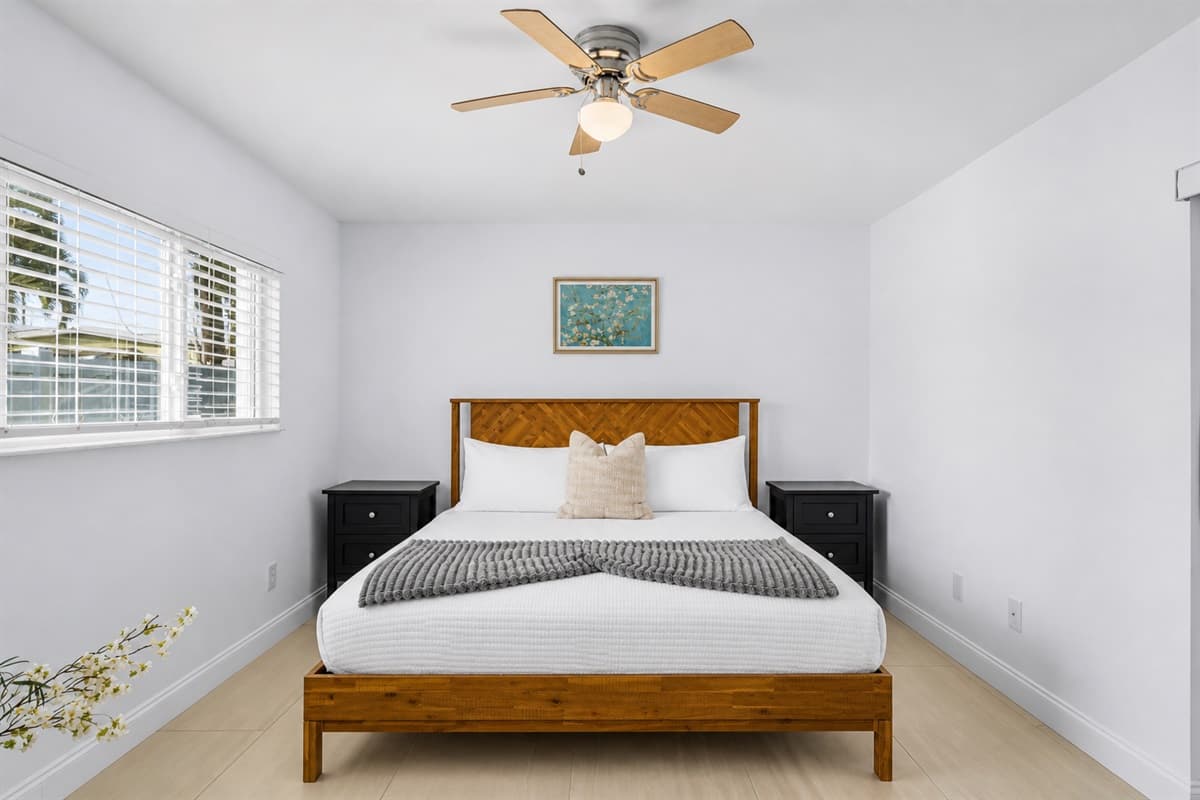Bright and airy bedroom featuring a cozy wooden bed frame, modern décor, and natural lighting.
