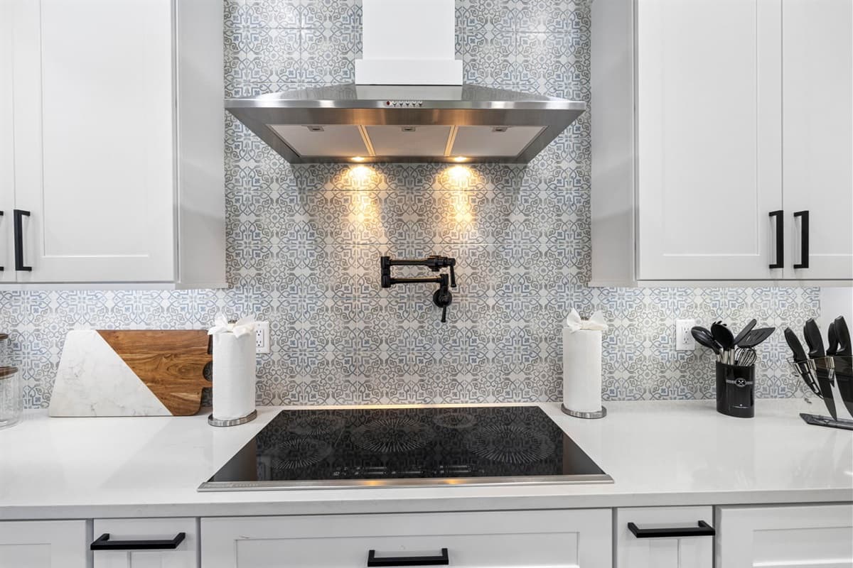 The kitchen is centered around pristine, gleaming white countertops that offer an abundance of workspace for chopping, mixing, and prepping meals. 