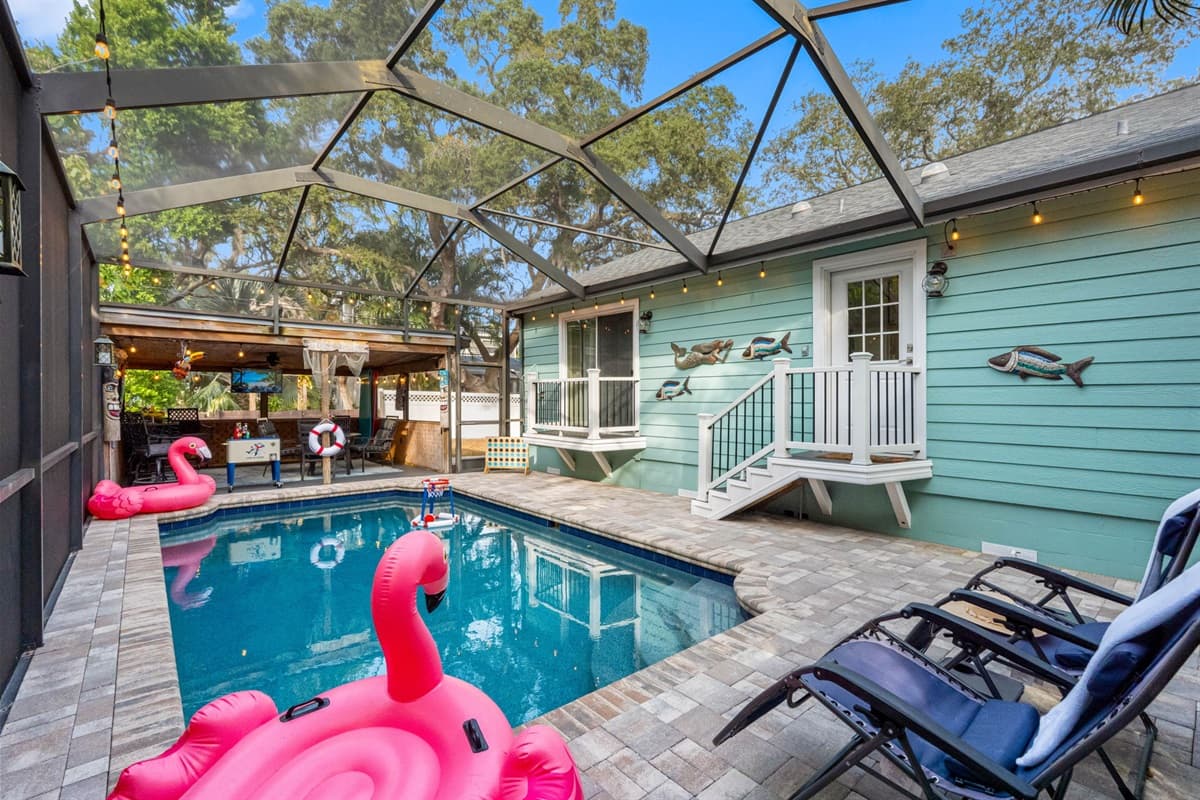 Bright and refreshing, the pool is surrounded by a paver deck, comfortable loungers, and a fully screened enclosure for added privacy.