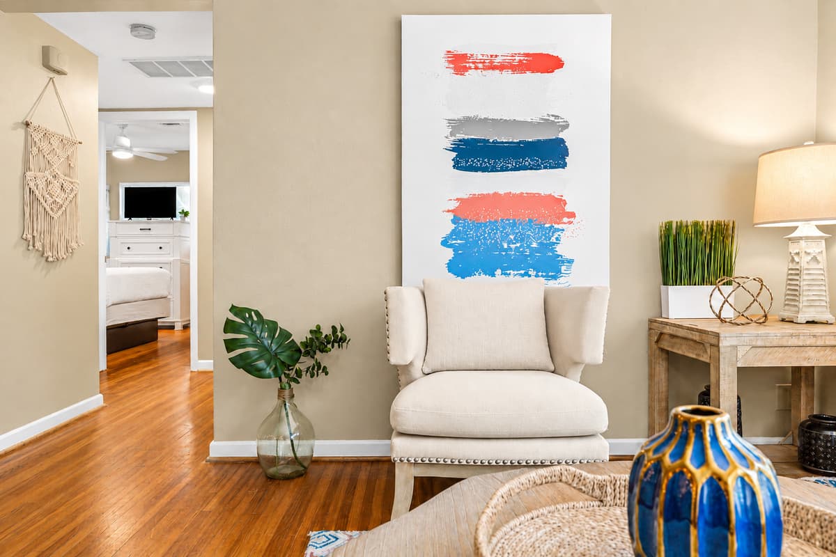 Stylish sitting nook with accent chair, modern artwork, and elegant decorative touches.