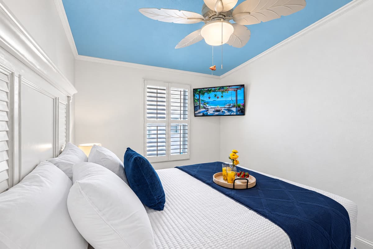 A soothing coastal palette and sky-blue ceiling create a relaxing atmosphere perfect for unwinding.