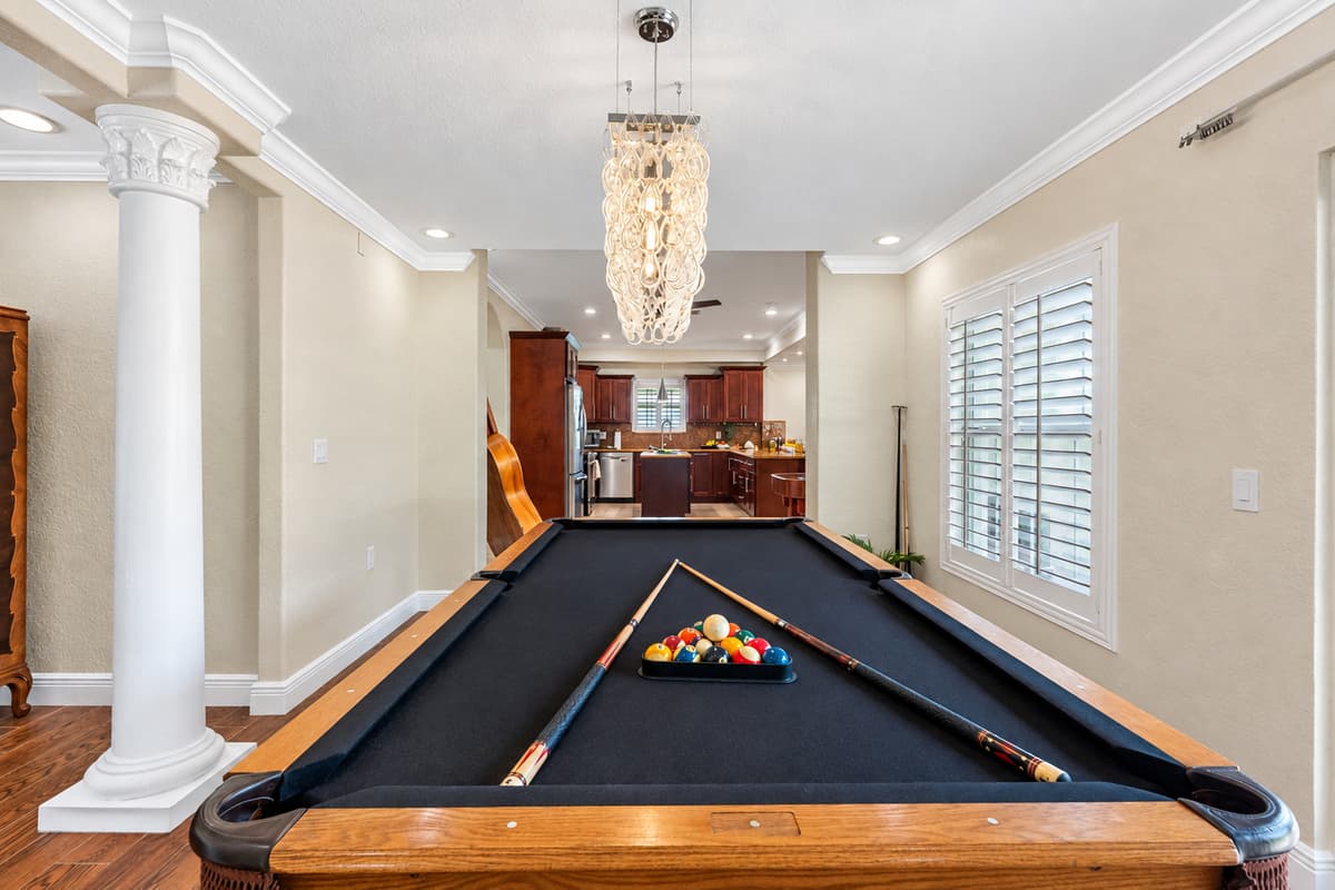 Enjoy a game of billiards while taking in the scenic waterfront backdrop. This game room boasts warm wood flooring, modern lighting, and easy access to the outdoor patio.