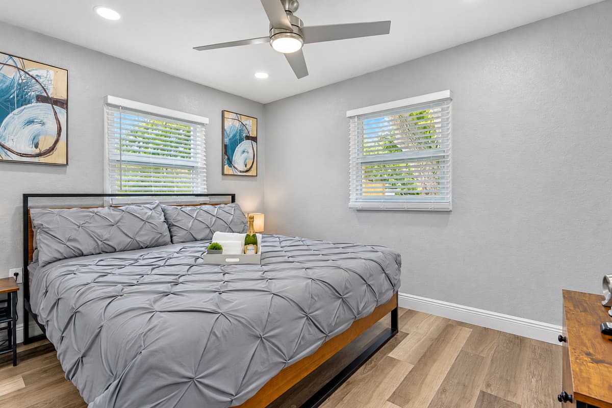 Sleep like royalty in the king room. A king bed with soft pintuck bedding, bedside lamps, and calm gray tones. After a day at Clearwater Beach, this is the room that makes everyone fight over who gets it.