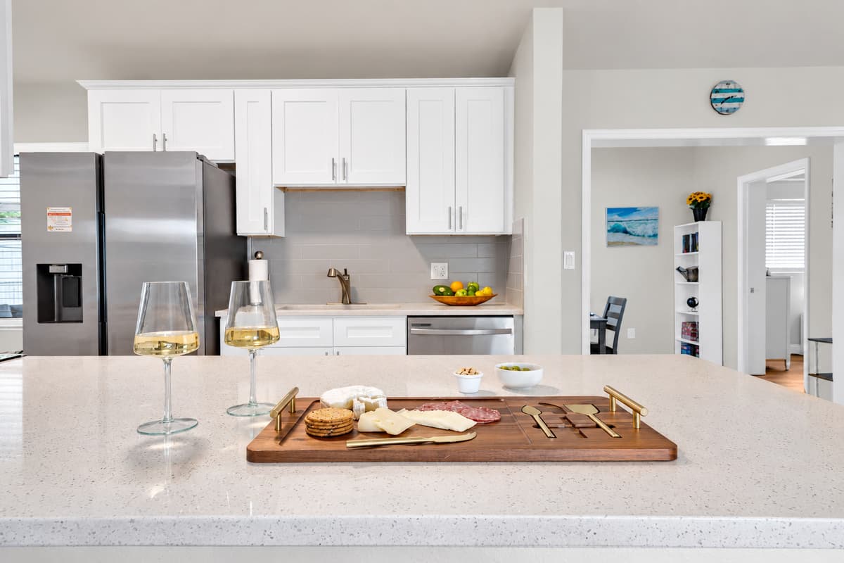 A wide counter with room to actually spread out: cutting board, glasses, groceries and two people working at once. Full-size fridge, ice maker and a dishwasher for when nobody feels like scrubbing.