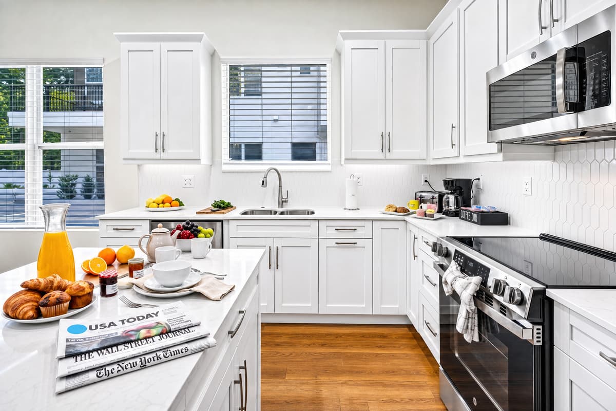 Everything a home kitchen should have, stainless appliances, generous counters, and morning light through the window over the sink.