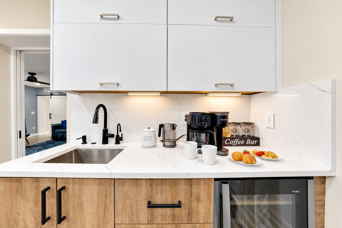 Second kitchenette, so nobody waits for anything. Sink, beverage fridge, coffee bar and counter of its own — snacks, drinks and midnight coffee without opening the main kitchen.