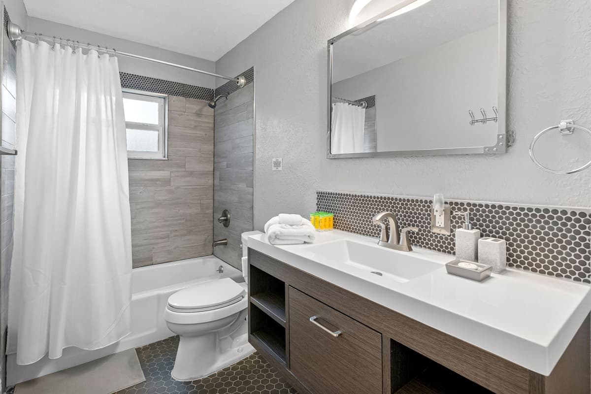 Clean and modern bathroom featuring a shower/tub combo and stylish finishes.