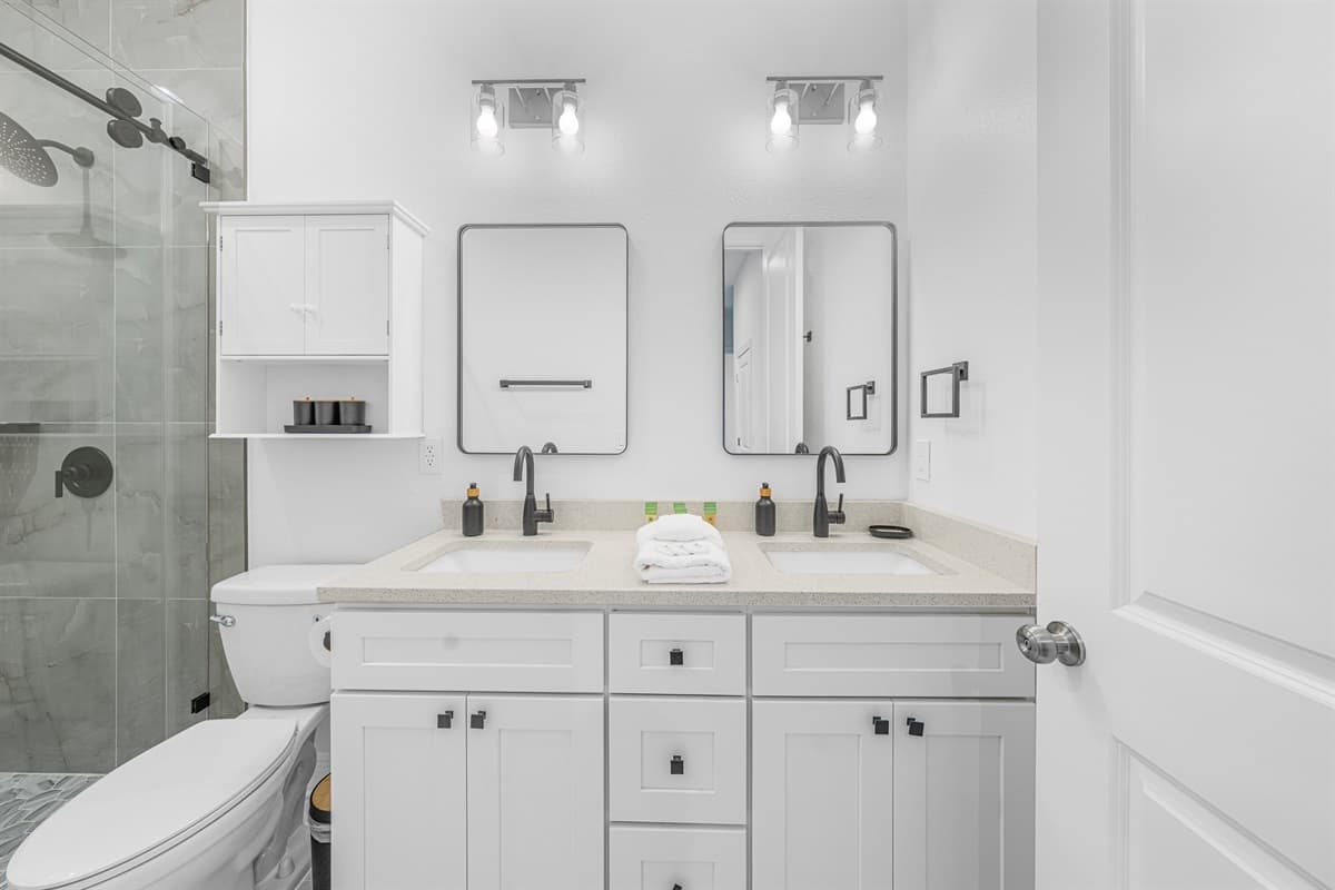 Modern bathroom with dual vanity, clean white cabinetry, and sleek contemporary finishes.