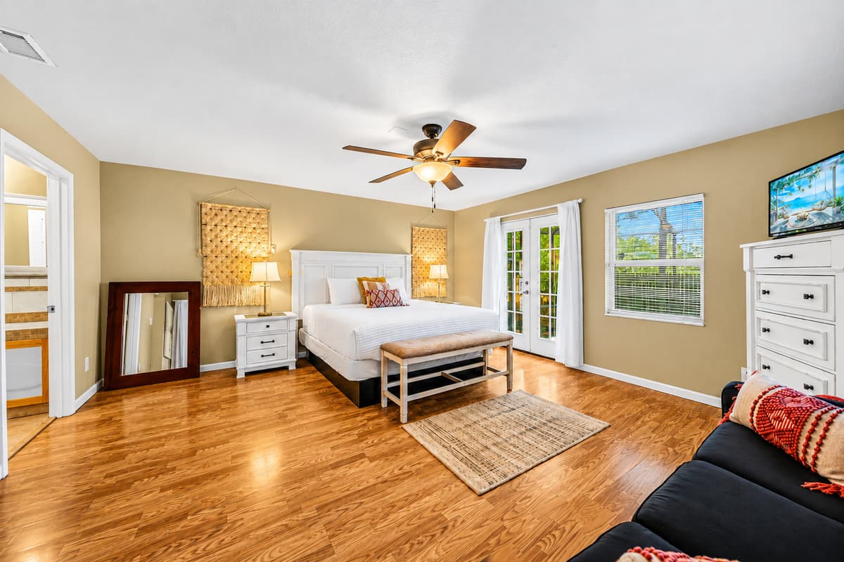 Bright and airy master suite with cozy seating, hardwood floors, and plenty of natural light.