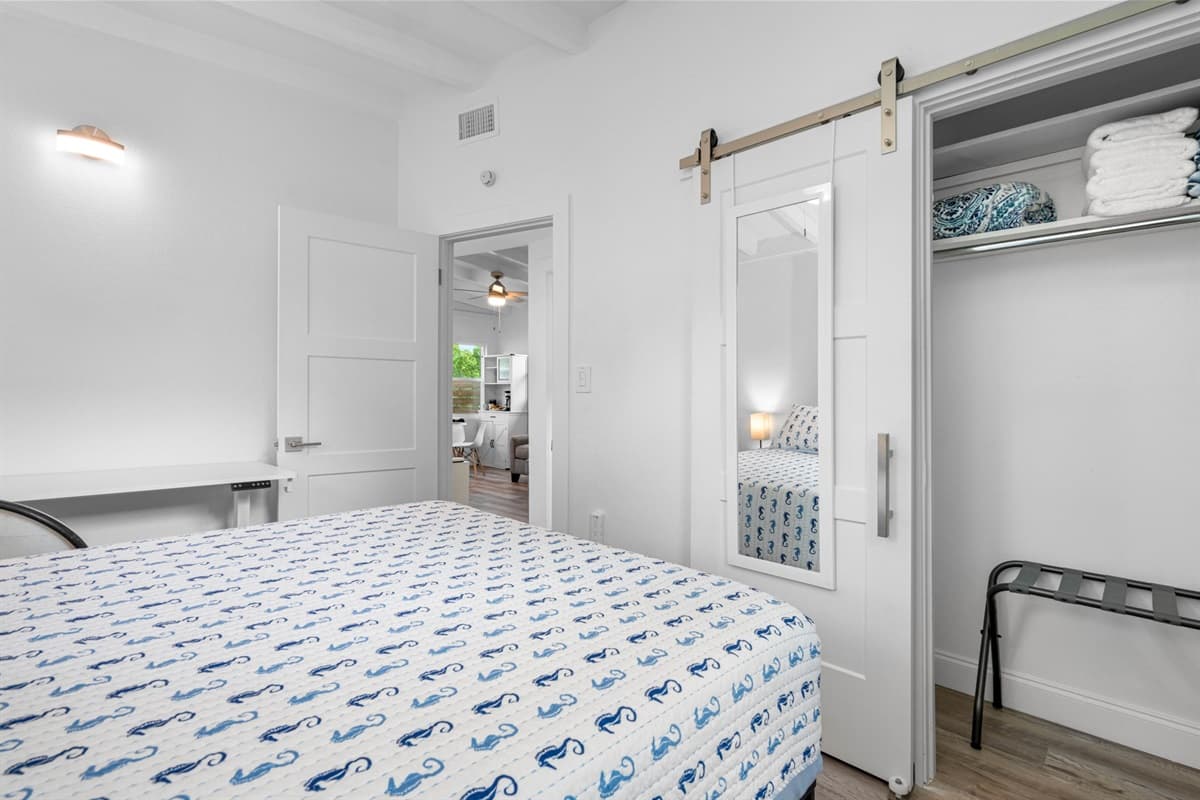 The room features ample storage solutions, including a spacious wardrobe and bedside tables, to keep your belongings organized and within easy reach.