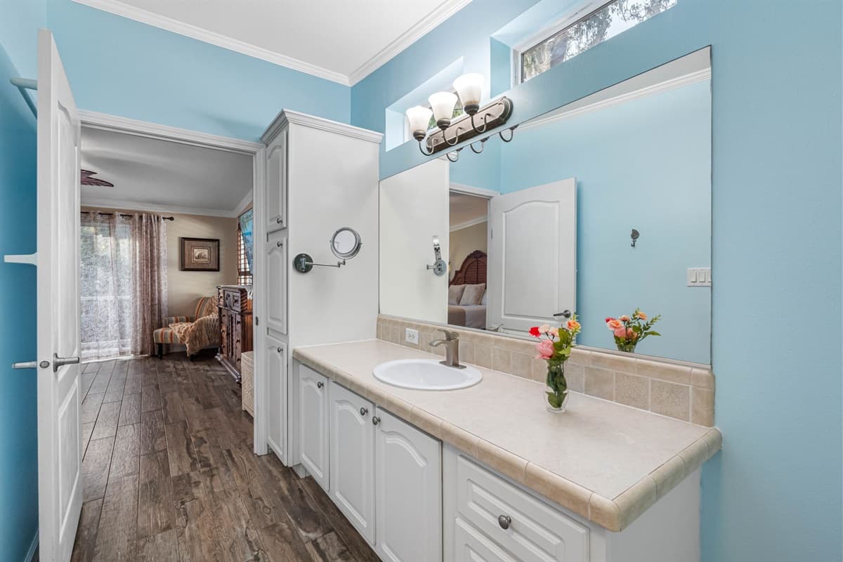 Calming sky-blue walls, tasteful artwork, and warm natural-wood flooring create a soothing coastal ambiance throughout.