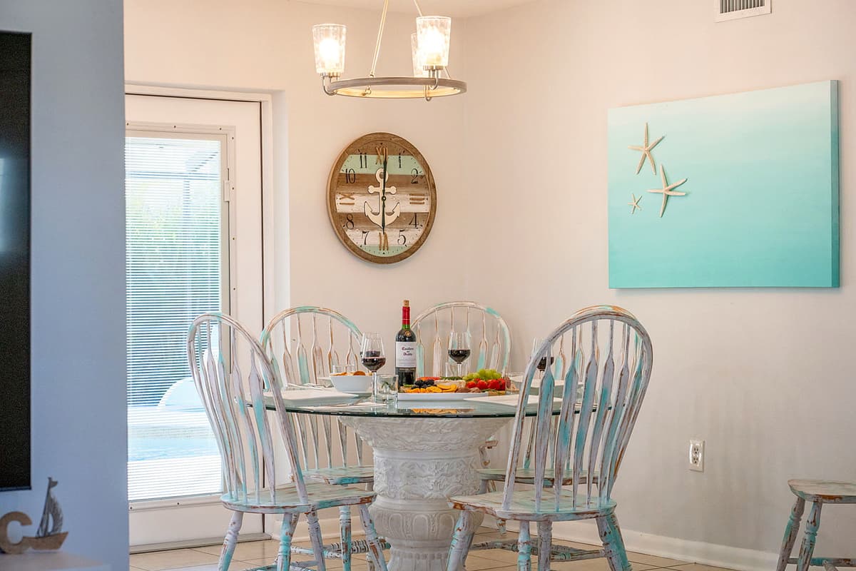 Adjacent to the kitchen, the dining area offers a cozy yet elegant spot for meals, featuring a stylish round glass table with seating for up to five guests.