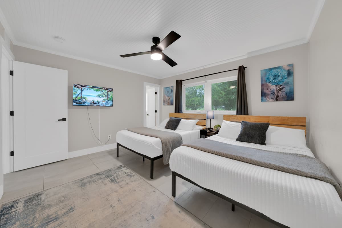Closer in, the details show: soft gray throws, wood headboards, art that matches on both sides, nothing here feels mismatched.