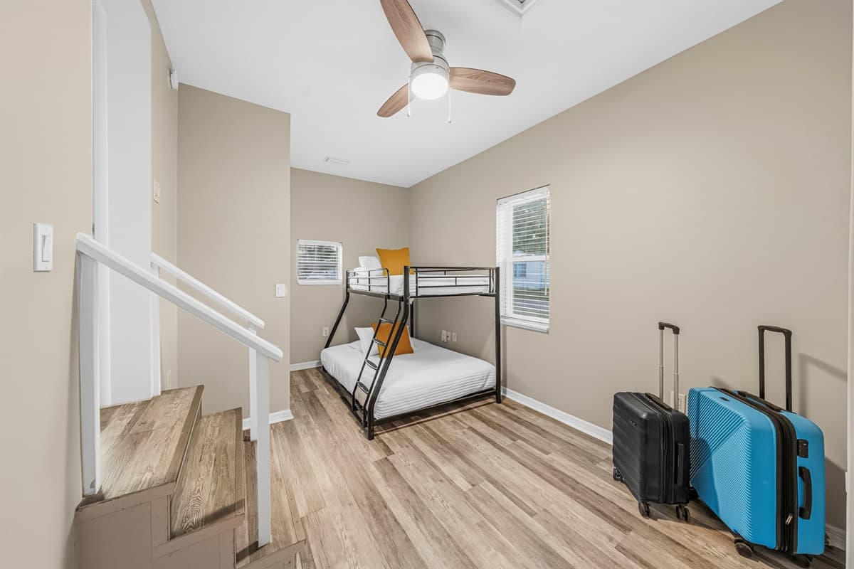 Bright bunk room with multiple beds and luggage space—ideal for larger groups or families.