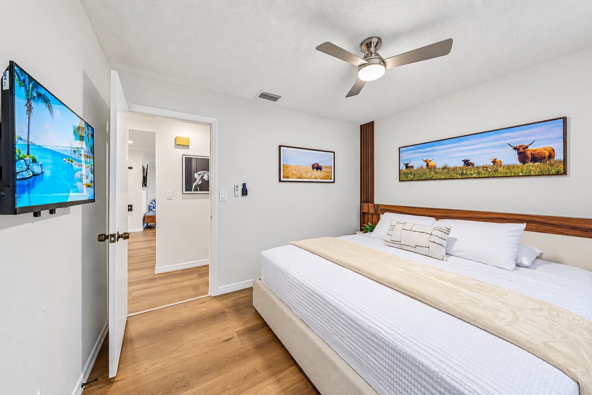 Large king bedroom featuring wall-mounted TV, modern décor, and plenty of open space to relax 