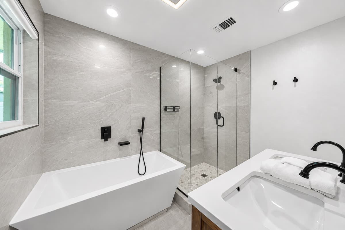 Primary bathroom showcasing a freestanding soaking tub, spacious walk-in shower, and contemporary design details.