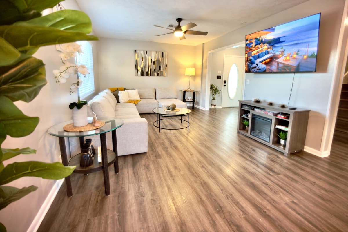 🛋️ Unwind in the stylish living room featuring a large flat-screen TV, ceiling fan, and chic modern décor. Perfect for movie nights or relaxing after a day of Florida fun! 🌿✨
