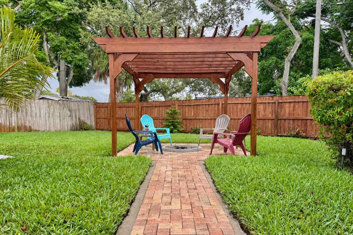 The perfect blend of natural wood, paver flooring, and cozy seating—this pergola space was made for memories.
