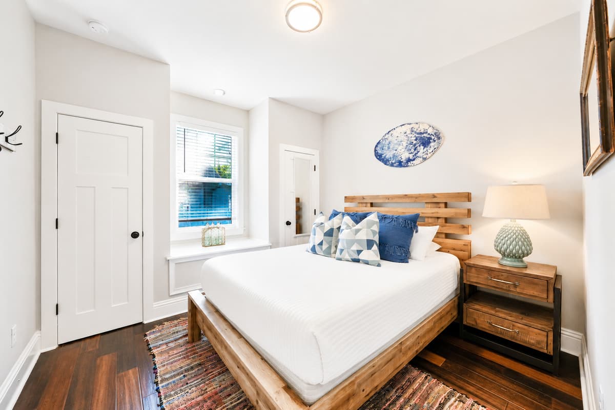 A welcoming guest bedroom with a comfortable queen-size bed, warm décor, and plenty of storage.
