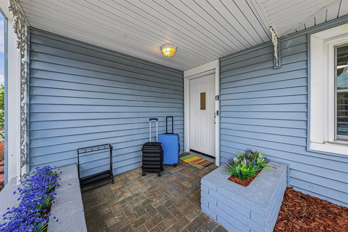 Covered front entry area with seating space and a welcoming feel for guests arriving 
