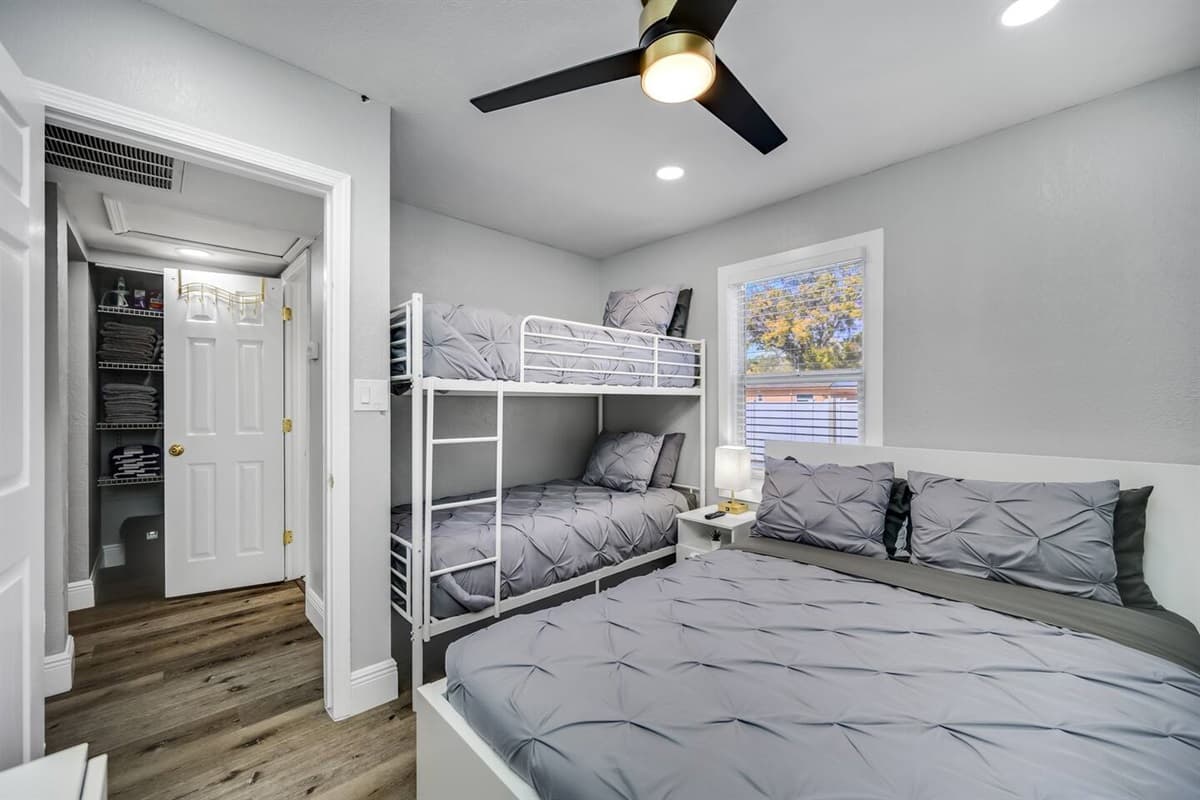 Immaculate bedroom with single bunkbed, queen sized bed, closet and smart TV.