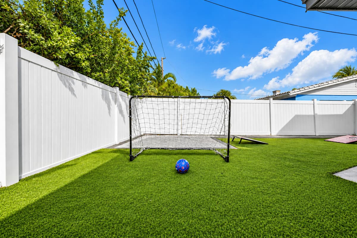Private backyard soccer area with artificial turf and secure fencing.