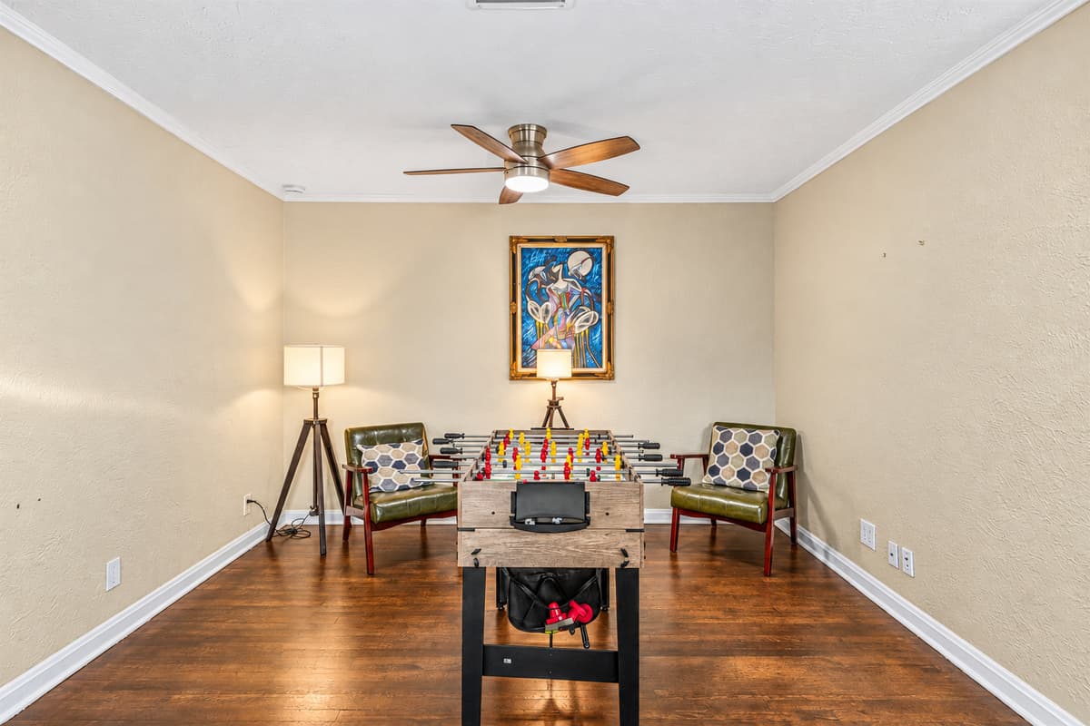 Stylish game room setup with foosball table and lounge chairs for relaxing between games.