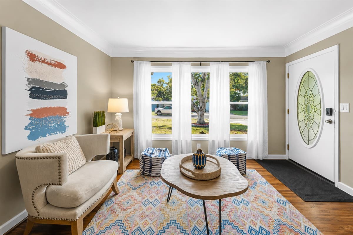 Bright front sitting area with large windows, cozy seating, and welcoming natural light.