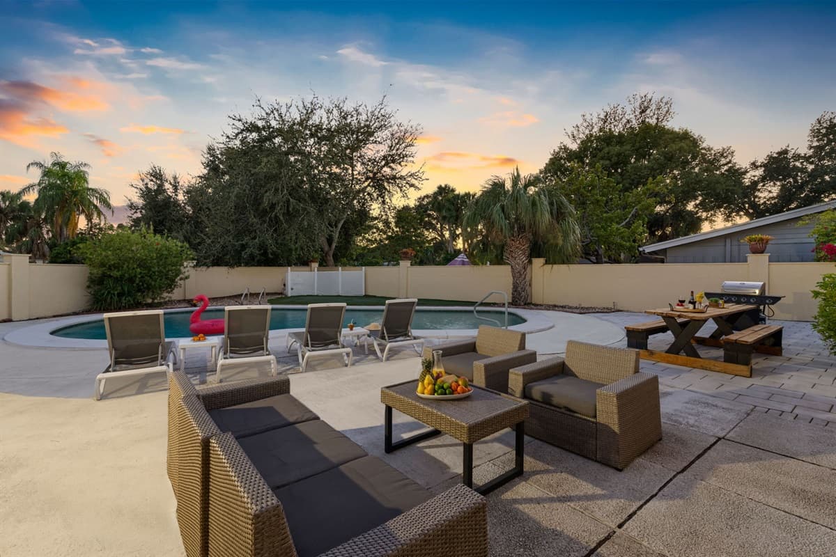 Enjoy golden sunsets by the pool, with plenty of seating, a BBQ grill, and a cozy outdoor dining setup for evening gatherings.