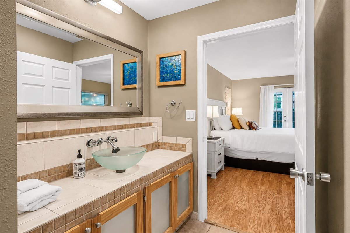 Cozy ensuite bathroom with stylish finishes, warm tones, and convenient bedroom access.