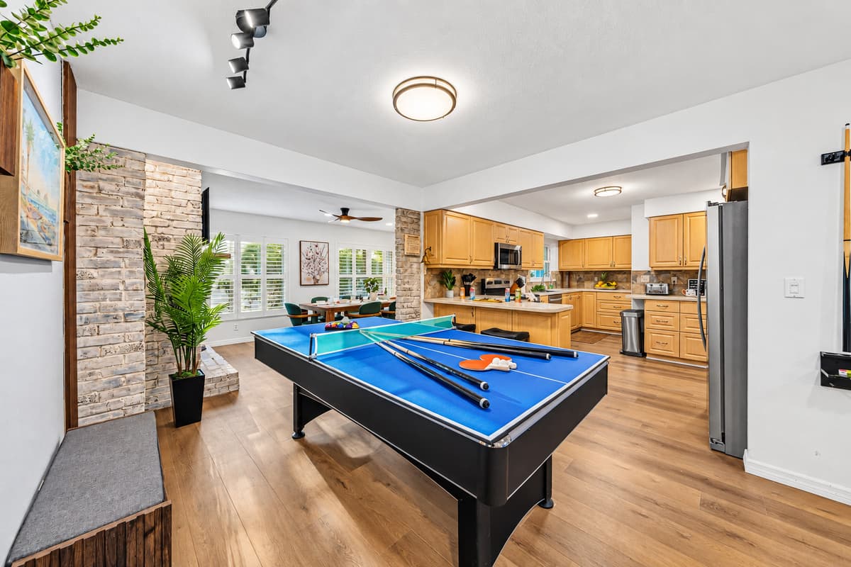 Large open layout showcasing the game area flowing into the kitchen and living spaces 