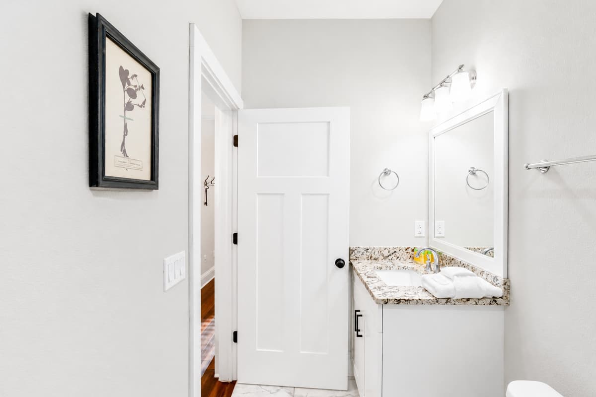 A modern bathroom featuring a granite vanity, fresh towels, and all the essentials for a comfortable stay.