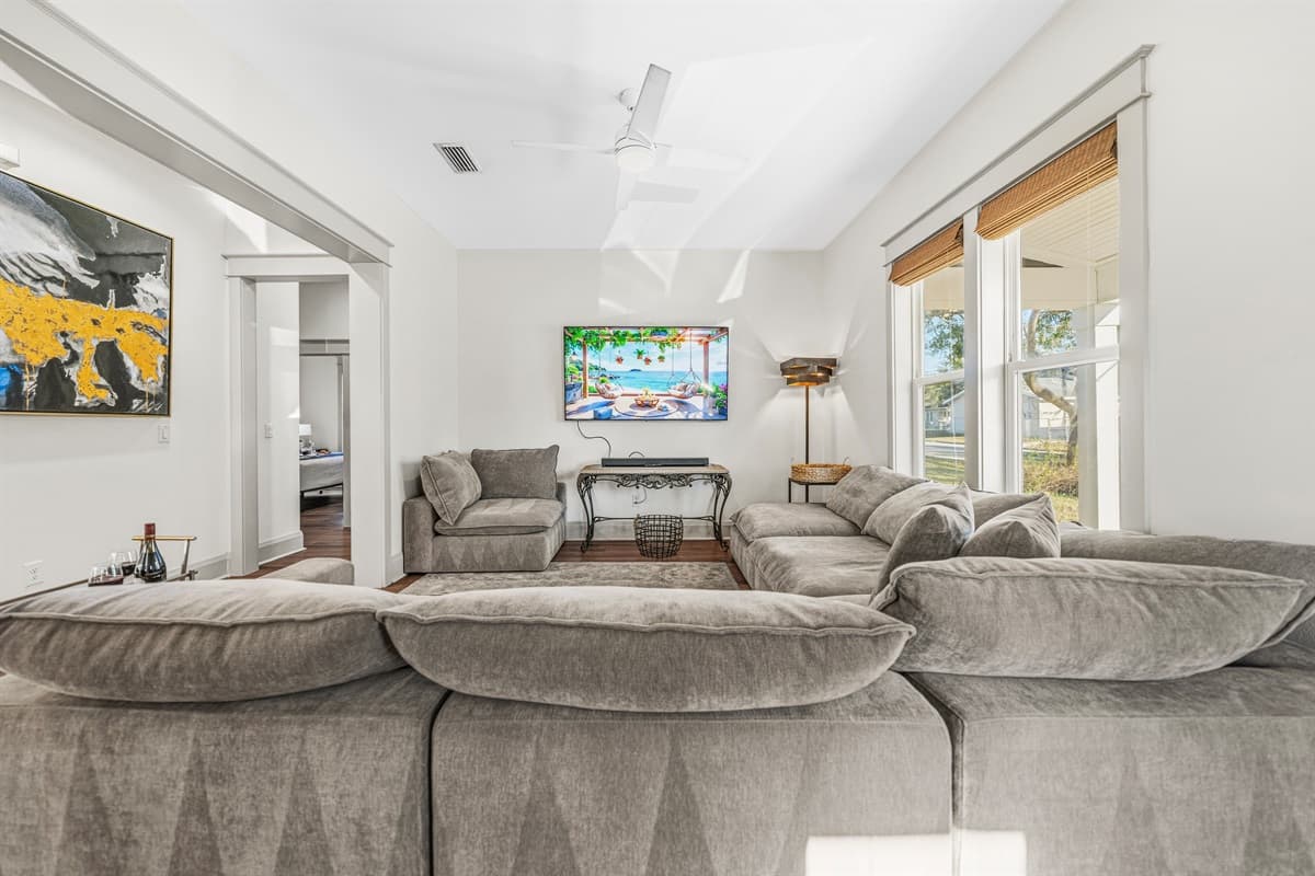 Sink into the ultra-cozy oversized sectional sofa in this bright, airy living space. Bamboo roman shades filter beautiful natural light while bold original artwork adds personality to this brand-new Seminole Heights home.