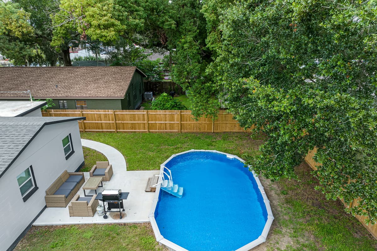 The top aerial view of our beautiful property showcasing the beautiful fully fenced backyard and the stunning heated pool. Enjoy the view outside showcasing beautiful trees in the area. Don't hesitate and book this property now!