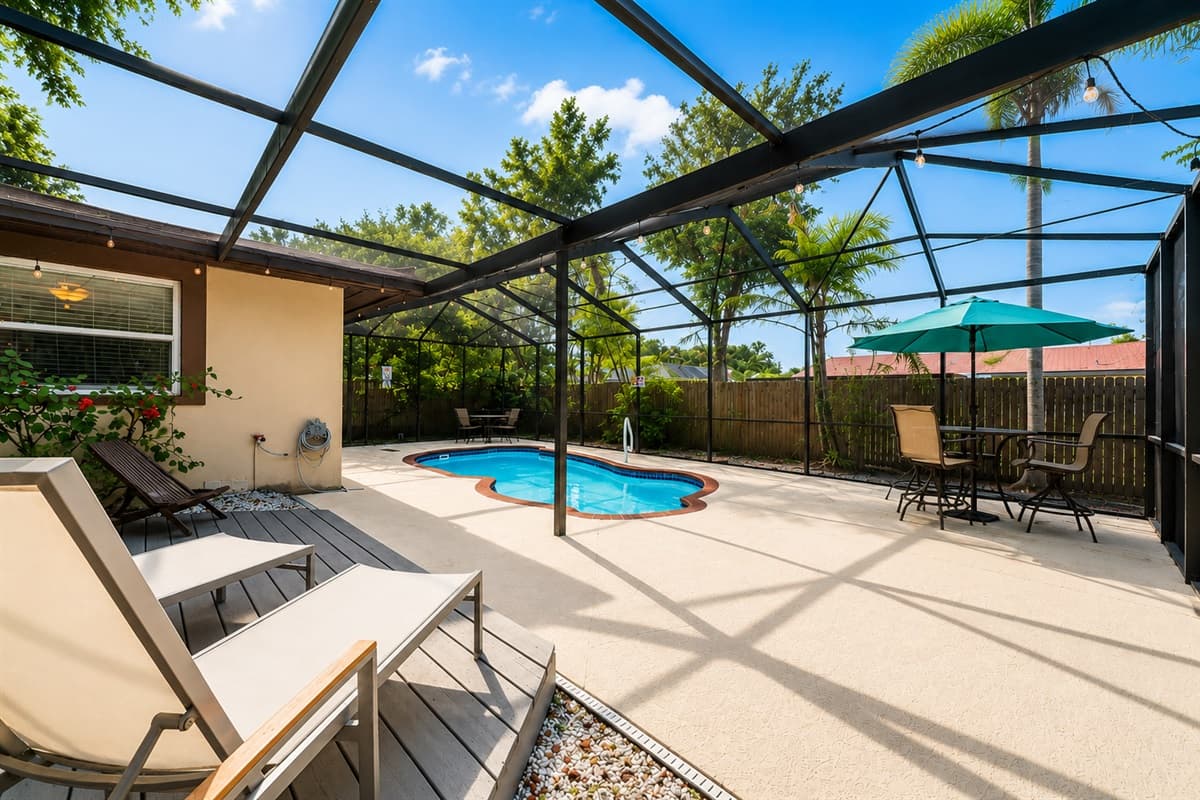 Inviting pool deck with lounge chairs, outdoor dining space, and tropical surroundings.