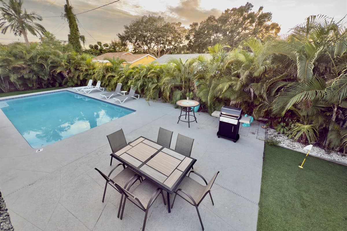 Enjoy a spacious backyard oasis featuring a sparkling private pool, outdoor dining area, and a modern grill for family cookouts.