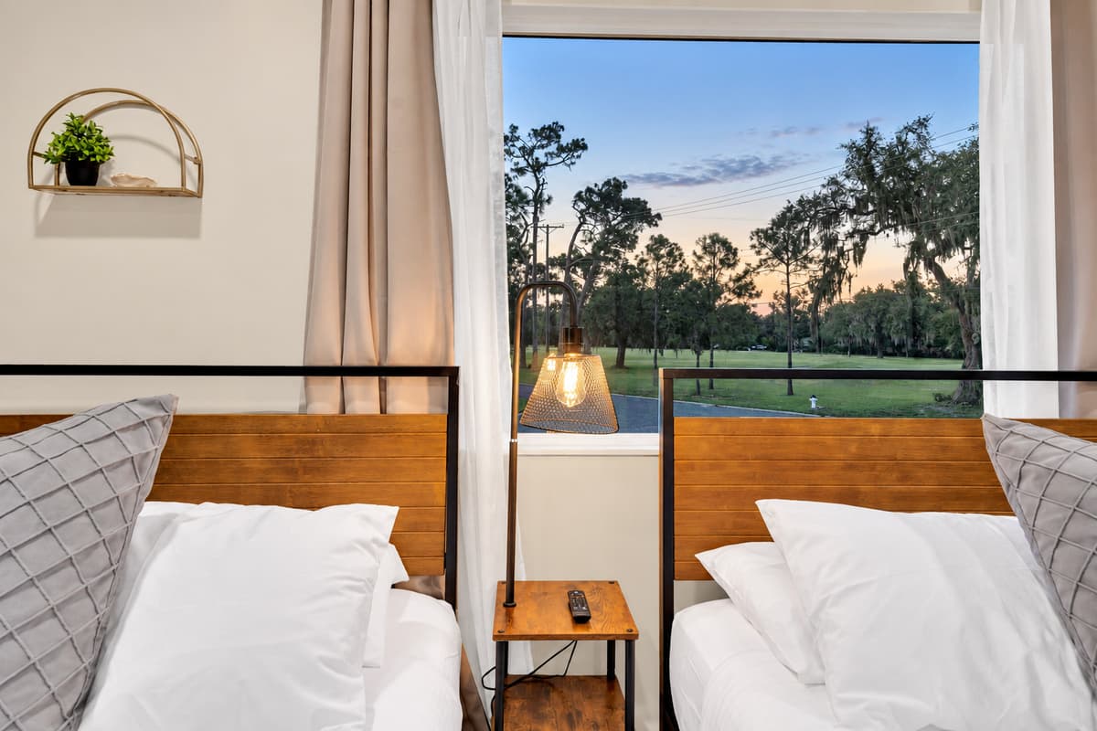 Open the curtain and the lawn is right there. Wake to green trees and Florida light, with the pool a short walk away — the bedroom that makes early mornings feel like the best part of the day.