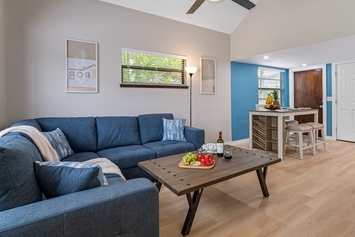 As you step into this inviting space, you're greeted by a captivating blue sofa that instantly catches your eye.