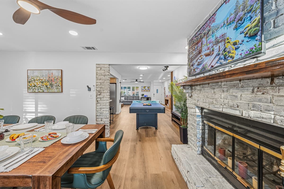 Dining area with a stunning fireplace feature and open view into the game space—great for entertaining 