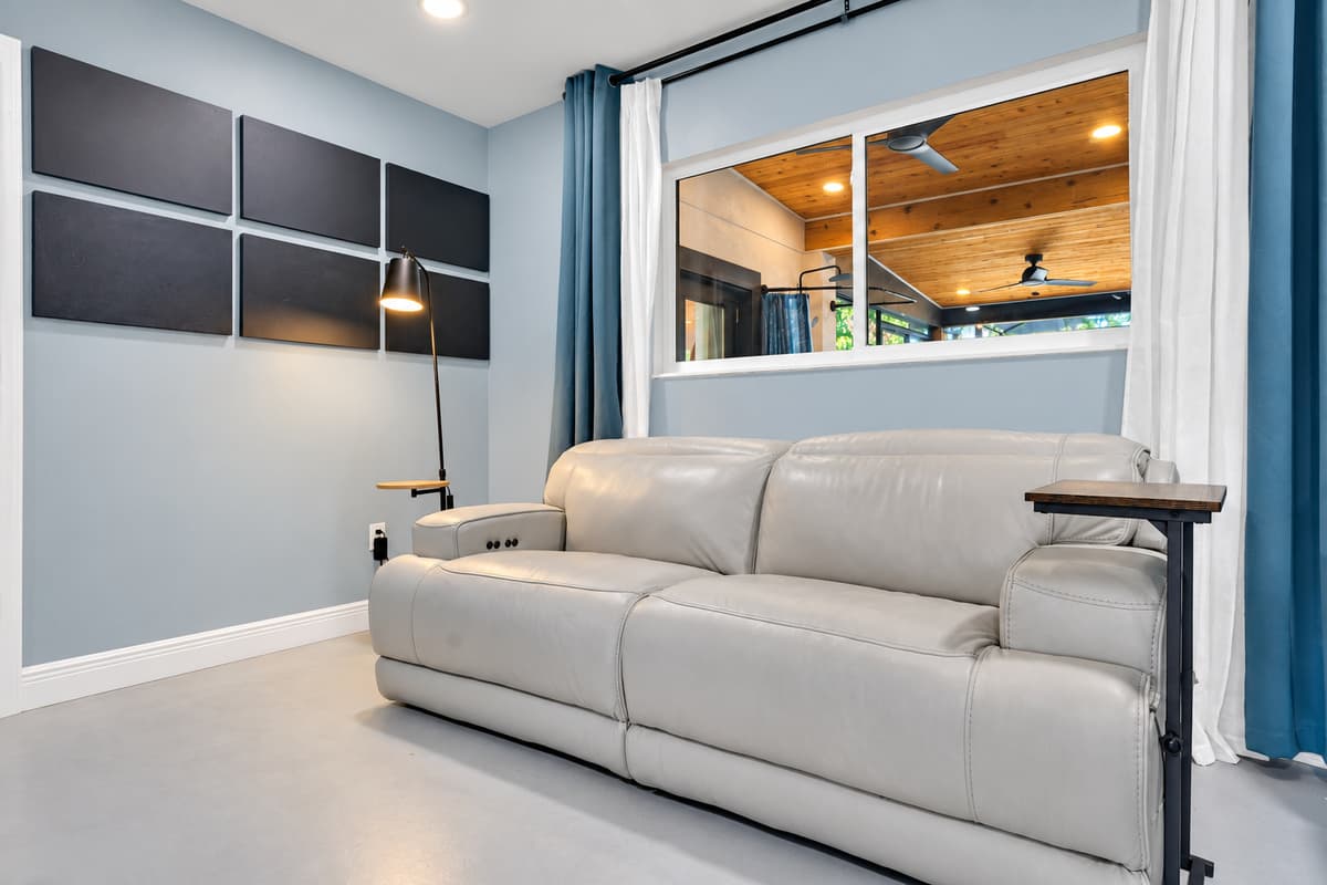 Sit up here and watch the pool below. Big windows over the lanai, comfortable seating and calm light — the vantage point the adults quietly claim on day one.