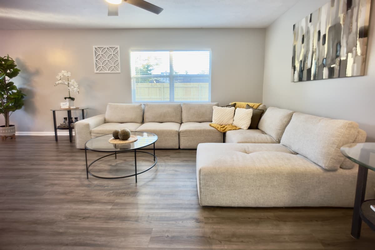 🛋️ Gather and relax in this bright, open living room with a huge sectional sofa — the ultimate spot to lounge, catch up with family, or binge your favorite shows on the smart TV! 📺🌟